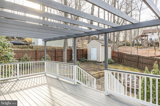 wooden deck featuring a fenced backyard, an outdoor structure, and a shed