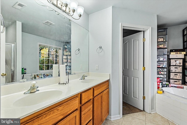 bathroom featuring vanity, tile patterned floors, and tiled tub