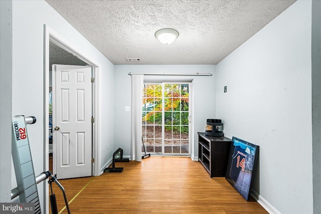 foyer entrance with wood-type flooring and a textured ceiling