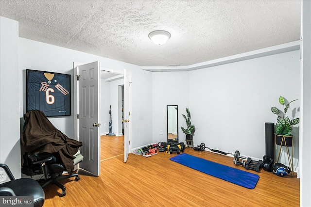 workout room with hardwood / wood-style floors and a textured ceiling