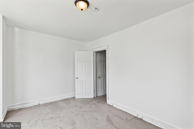 unfurnished room featuring light colored carpet