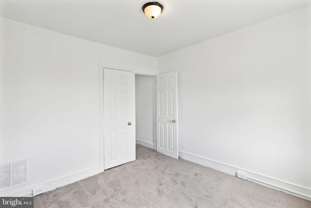 spare room featuring light colored carpet