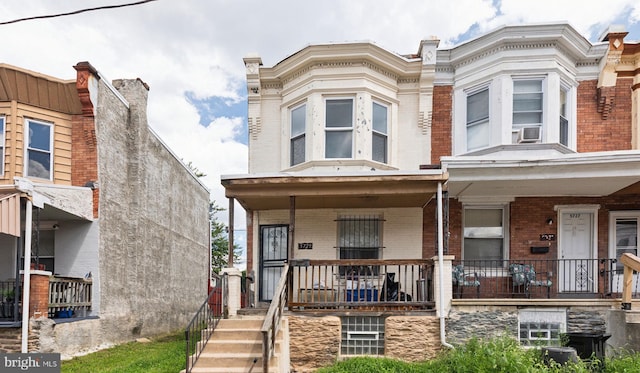 townhome / multi-family property with cooling unit and covered porch