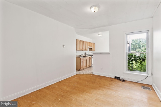 unfurnished living room featuring light hardwood / wood-style flooring and sink