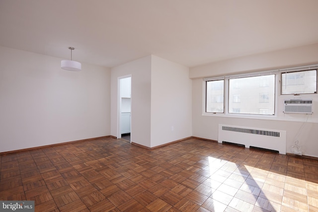 empty room featuring radiator, dark parquet flooring, and cooling unit