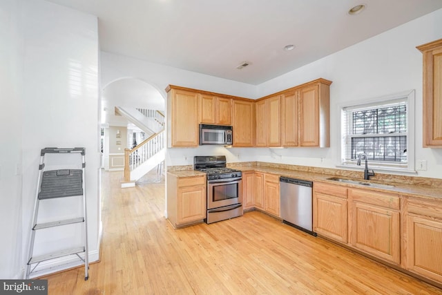 kitchen with light wood-type flooring, stainless steel appliances, and sink