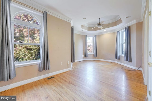 unfurnished room featuring ceiling fan, light hardwood / wood-style floors, ornamental molding, and a wealth of natural light