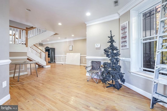 sitting room with light hardwood / wood-style floors and crown molding