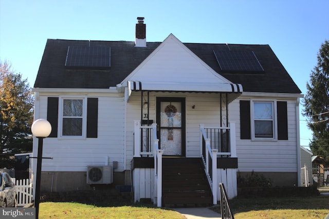 view of front of property with ac unit, solar panels, and a front lawn