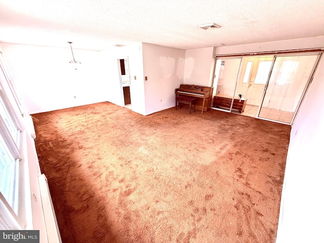 carpeted spare room featuring a textured ceiling