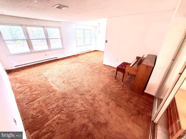 spare room with a baseboard radiator, carpet flooring, and a textured ceiling