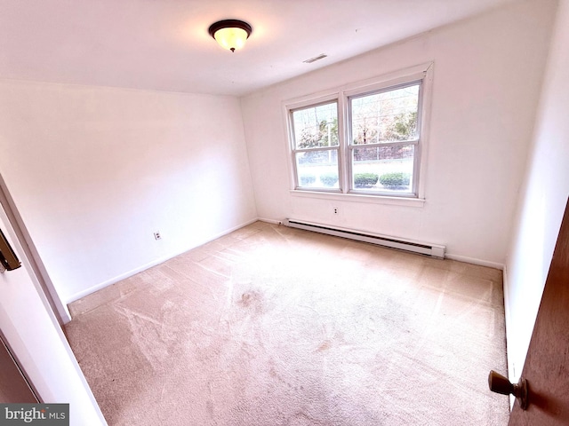 unfurnished room featuring a baseboard heating unit and carpet