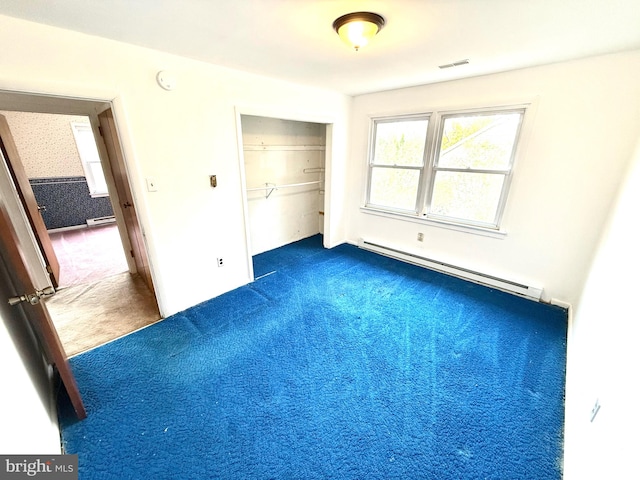 unfurnished bedroom featuring dark colored carpet, a baseboard radiator, and a closet