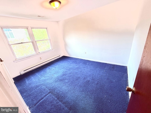 carpeted empty room featuring a baseboard heating unit