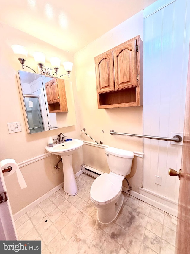 bathroom with toilet, sink, and a baseboard heating unit