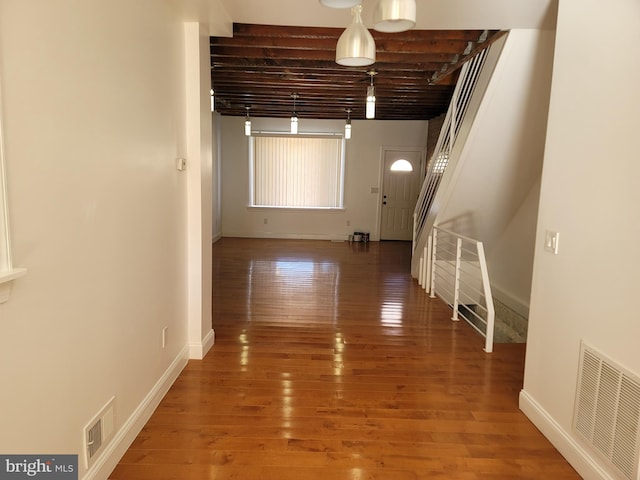 hall with baseboards, light wood-style flooring, and stairway