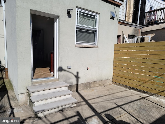 view of patio featuring entry steps and fence
