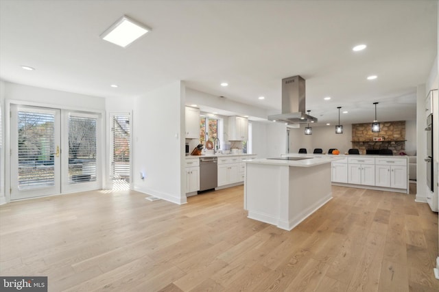 kitchen featuring light hardwood / wood-style floors, island range hood, pendant lighting, and dishwasher