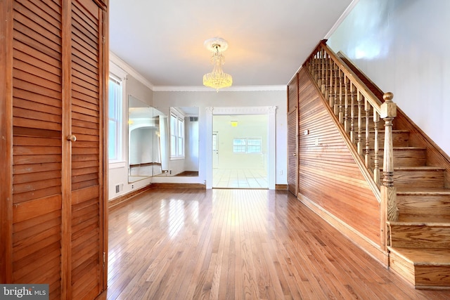 entryway featuring hardwood / wood-style floors, wood walls, and crown molding