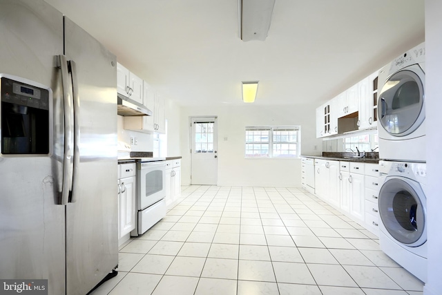 kitchen with white cabinets, white electric stove, stainless steel fridge, light tile patterned floors, and stacked washer / drying machine