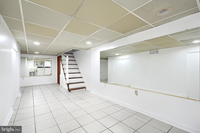 basement featuring a drop ceiling and tile patterned flooring