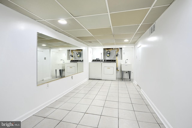 kitchen with independent washer and dryer, light tile patterned floors, a drop ceiling, and sink