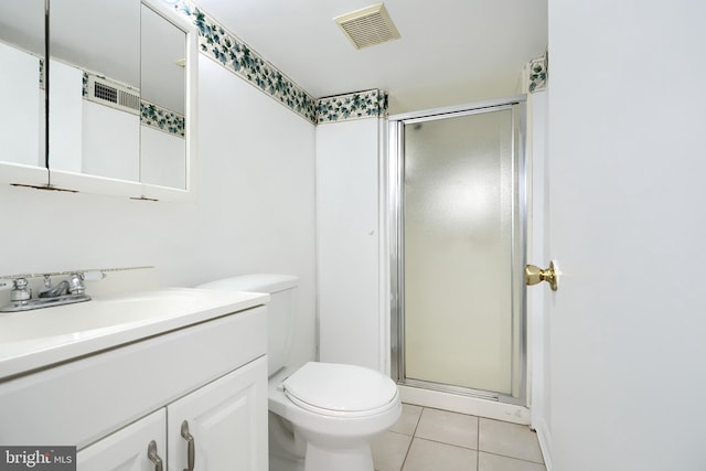 bathroom with toilet, vanity, tile patterned floors, and a shower with shower door