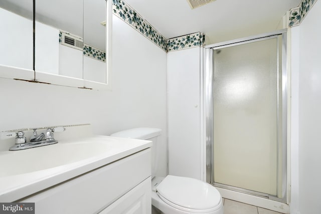 bathroom with tile patterned floors, vanity, toilet, and a shower with shower door