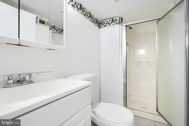 bathroom featuring tile patterned floors, vanity, toilet, and walk in shower