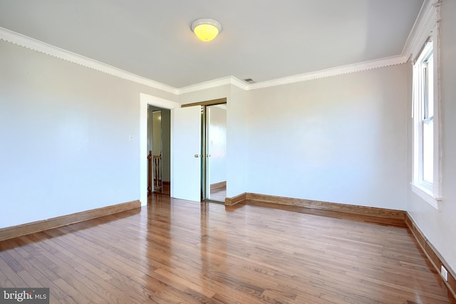 spare room featuring hardwood / wood-style floors and ornamental molding