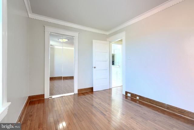 empty room featuring hardwood / wood-style floors and crown molding