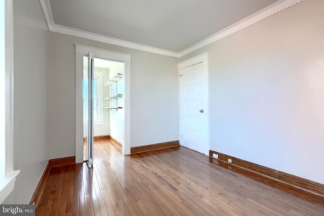 unfurnished room with crown molding and wood-type flooring