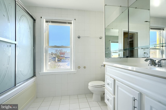 full bathroom with vanity, tile patterned floors, plenty of natural light, and tile walls