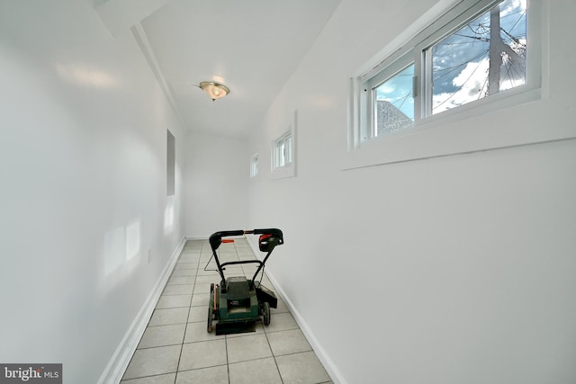 hallway with light tile patterned flooring and a healthy amount of sunlight