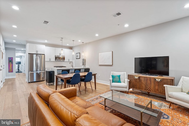 living room featuring light wood-type flooring and sink