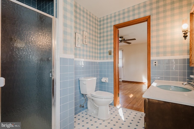 bathroom with tile walls, an enclosed shower, and wood-type flooring