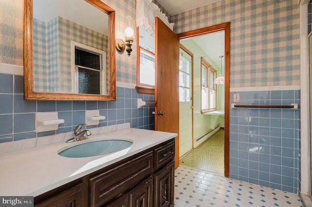 bathroom featuring vanity, tile walls, and a baseboard heating unit