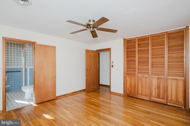 unfurnished bedroom with connected bathroom, a closet, ceiling fan, and light hardwood / wood-style floors