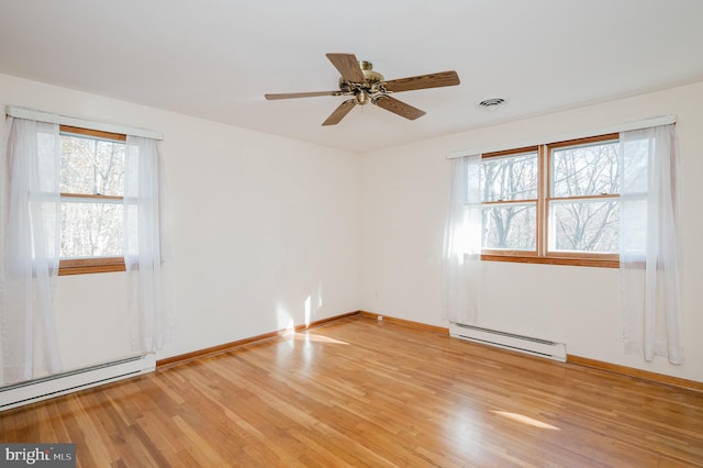 empty room with a baseboard heating unit, light wood-type flooring, and ceiling fan