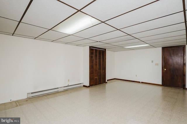 basement featuring a drop ceiling and a baseboard radiator