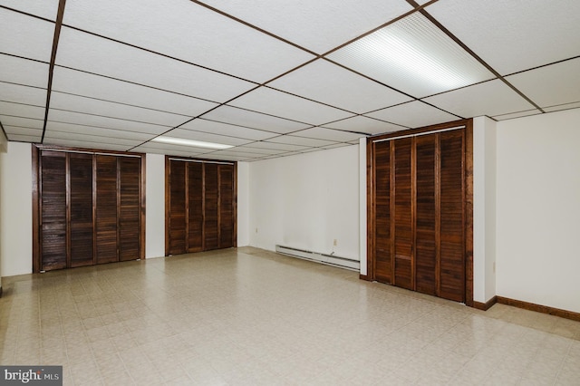 basement featuring baseboard heating and a paneled ceiling