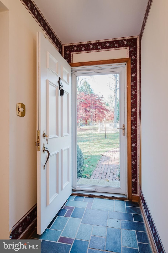 doorway to outside with ornamental molding