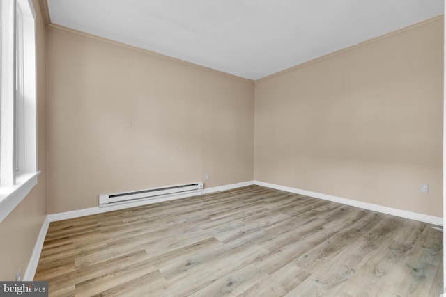 spare room featuring crown molding, a baseboard radiator, and light wood-type flooring