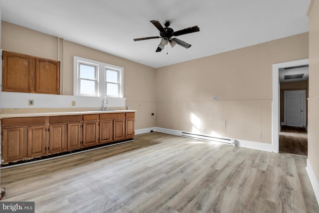 kitchen with light wood-type flooring, a baseboard radiator, ceiling fan, and sink