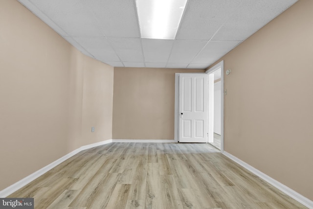 unfurnished room with a paneled ceiling and light hardwood / wood-style flooring