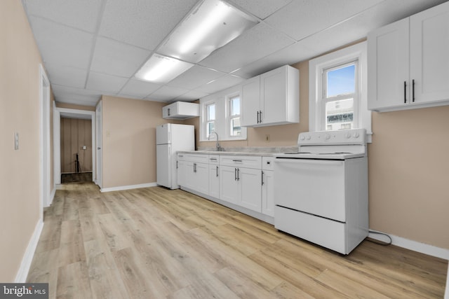 kitchen featuring white cabinetry, light hardwood / wood-style flooring, a drop ceiling, and white appliances