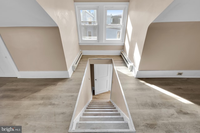 stairway with wood-type flooring and a baseboard radiator