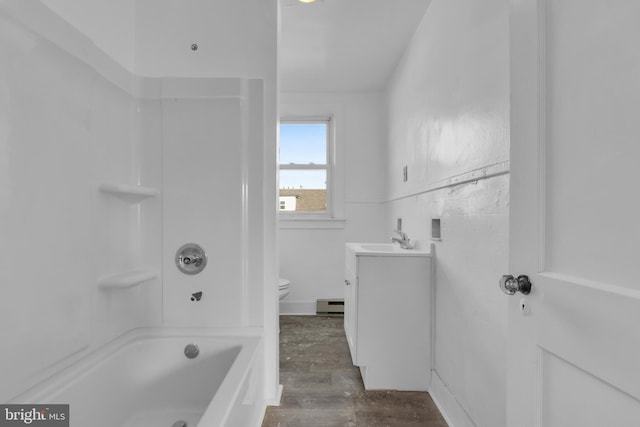 full bathroom featuring vanity, bathing tub / shower combination, hardwood / wood-style flooring, a baseboard radiator, and toilet