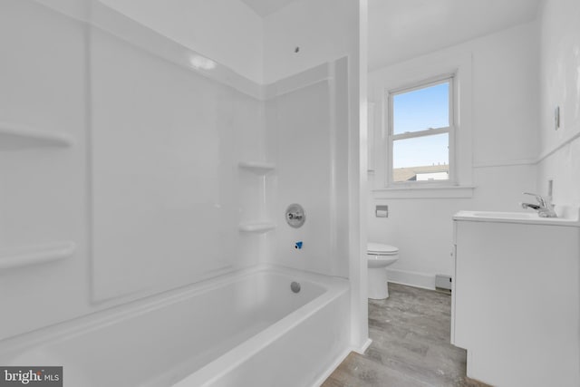 full bathroom featuring bathing tub / shower combination, vanity, hardwood / wood-style flooring, and toilet