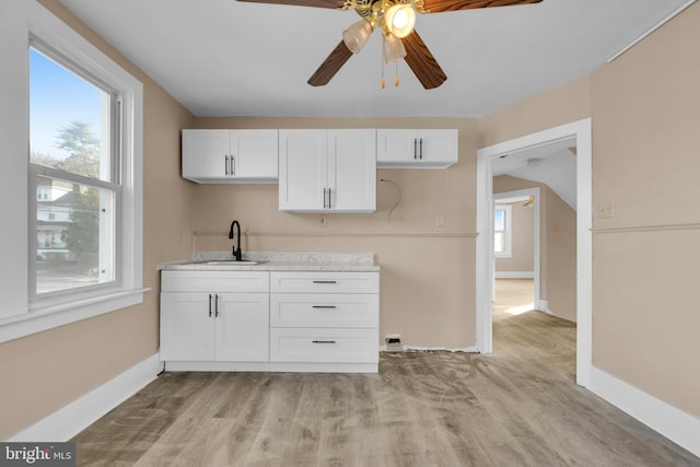 kitchen with ceiling fan, sink, white cabinets, and light wood-type flooring